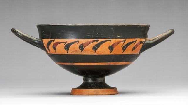 Image showing an ancient Greek vase with two handles, a skyphos, showing eight leaping dolphins in black on a red background.